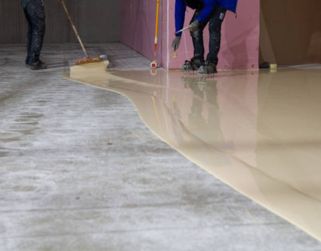 Durable flake epoxy coating being applied to a workshop floor